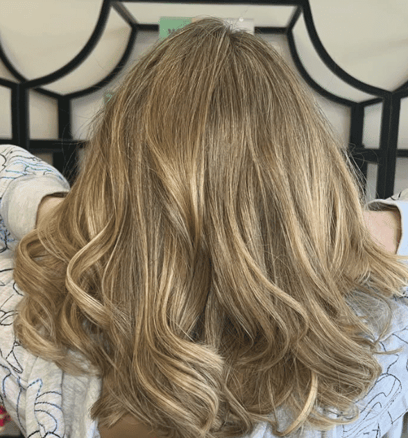 Blonde hair styled in loose, wavy curls.