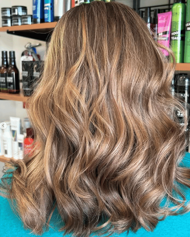 Wavy brown hair with highlights in a salon setting.