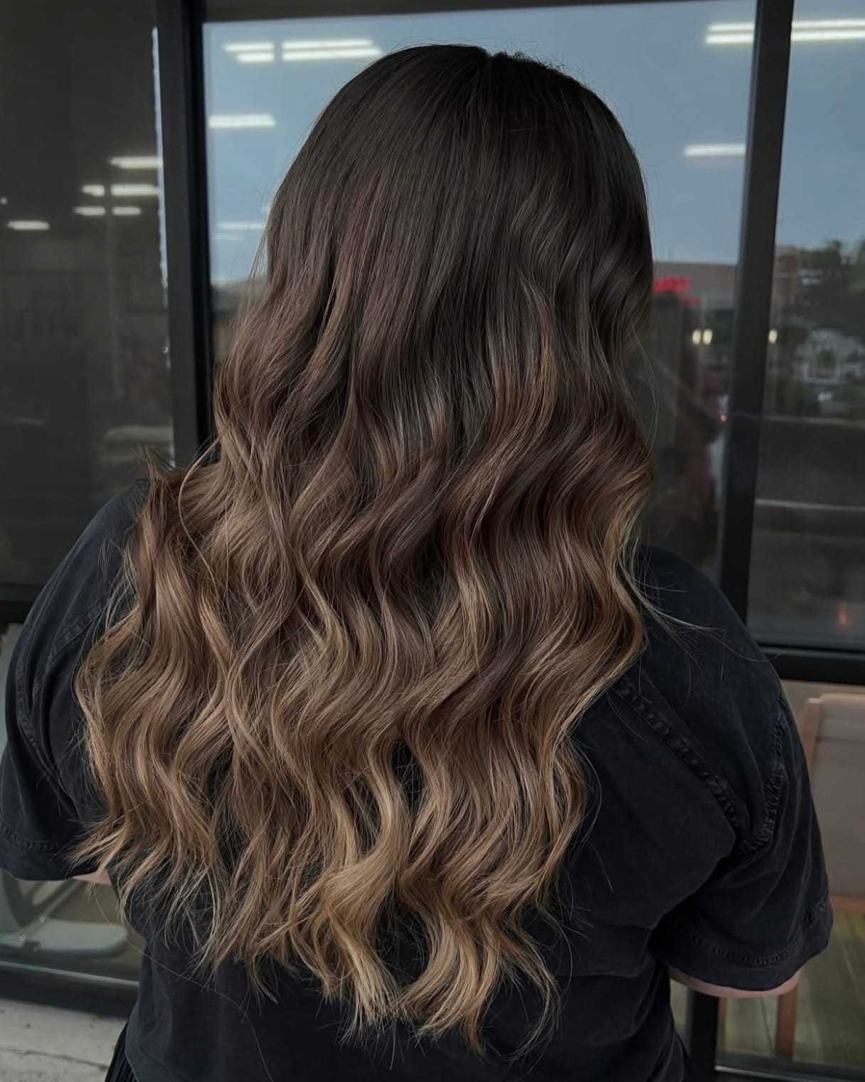 Wavy ombre hair with shades of brown and blonde, seen from the back.