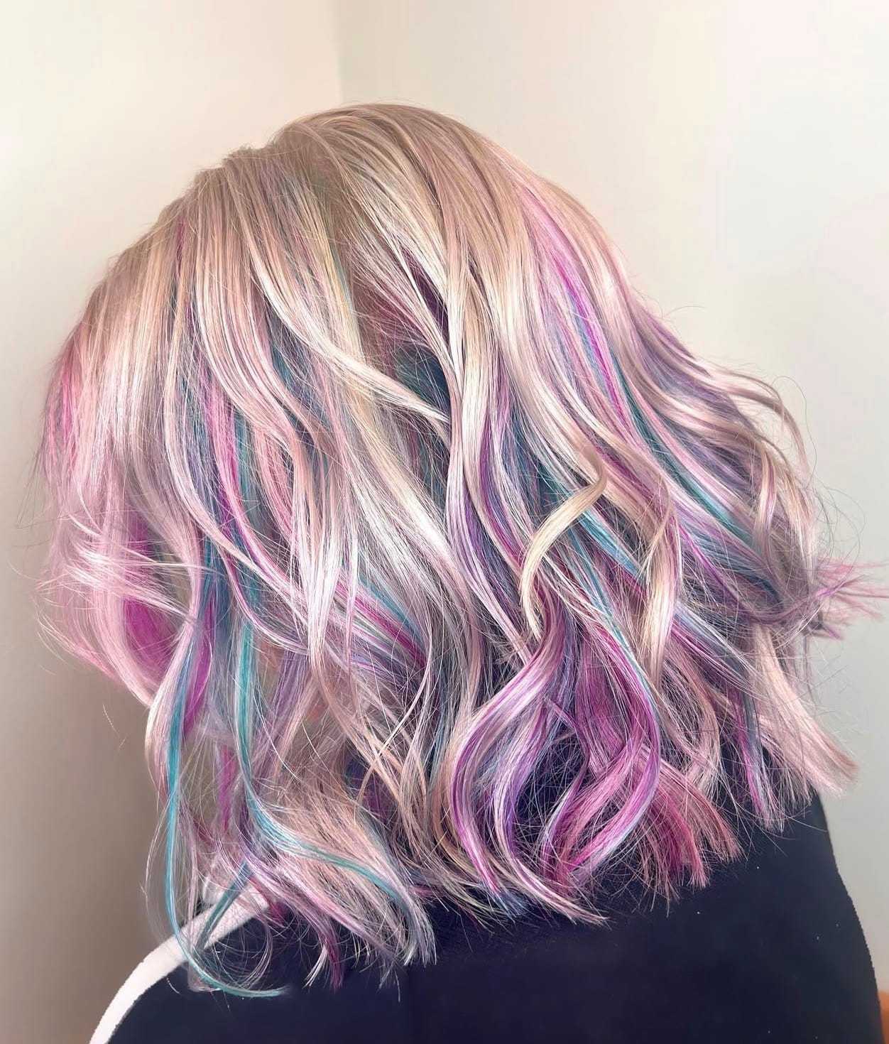 Pastel rainbow-colored wavy hair, showcasing shades of pink, blue, and purple in soft curls.
