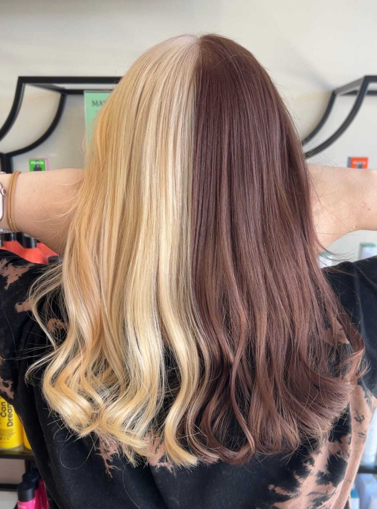 Two-tone hair with split blonde and brown colors, styled in soft waves.