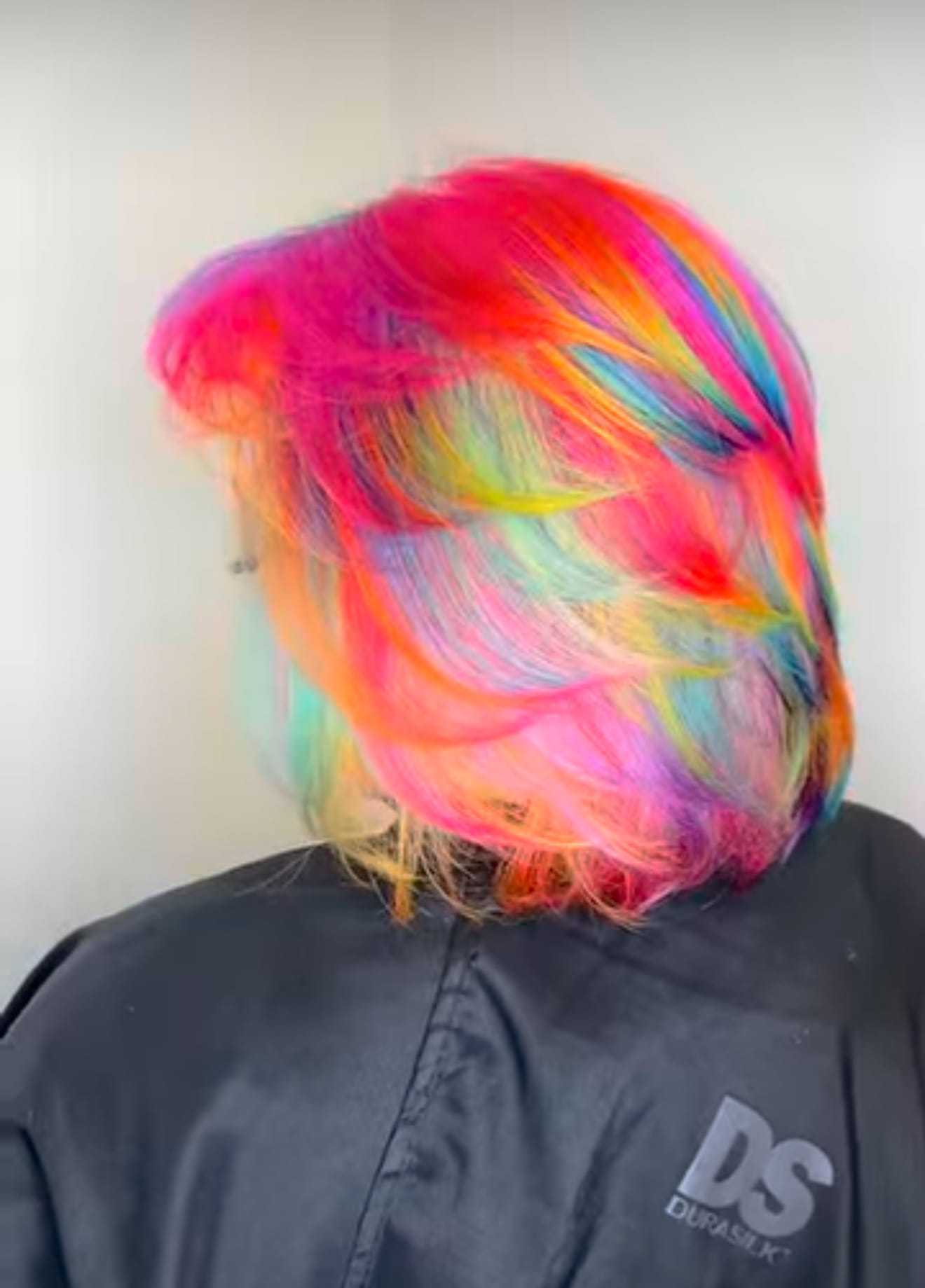 Vibrantly colored hair featuring a blend of pink, orange, blue, and green hues.