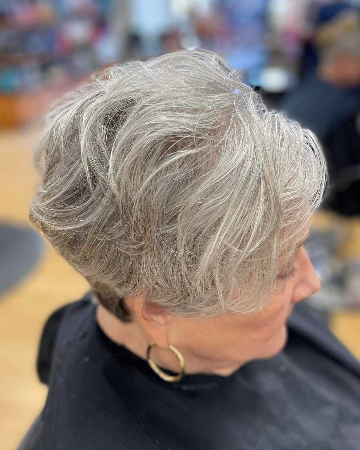 Short silver hairstyle on an older person in a salon, hair styled in soft waves.