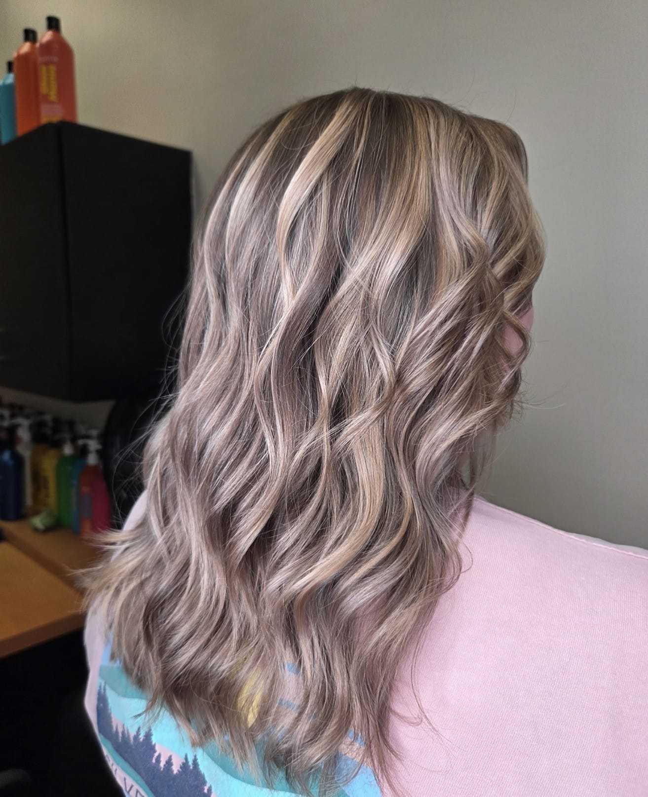 Wavy blond hair with highlights, styled for a casual look.