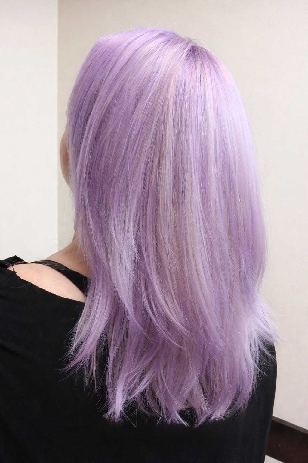 Person with lavender hair facing away, wearing a black top.