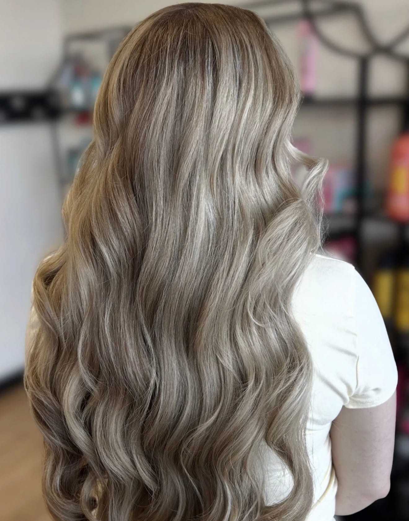 Long, wavy brunette hair styled elegantly in a salon setting.