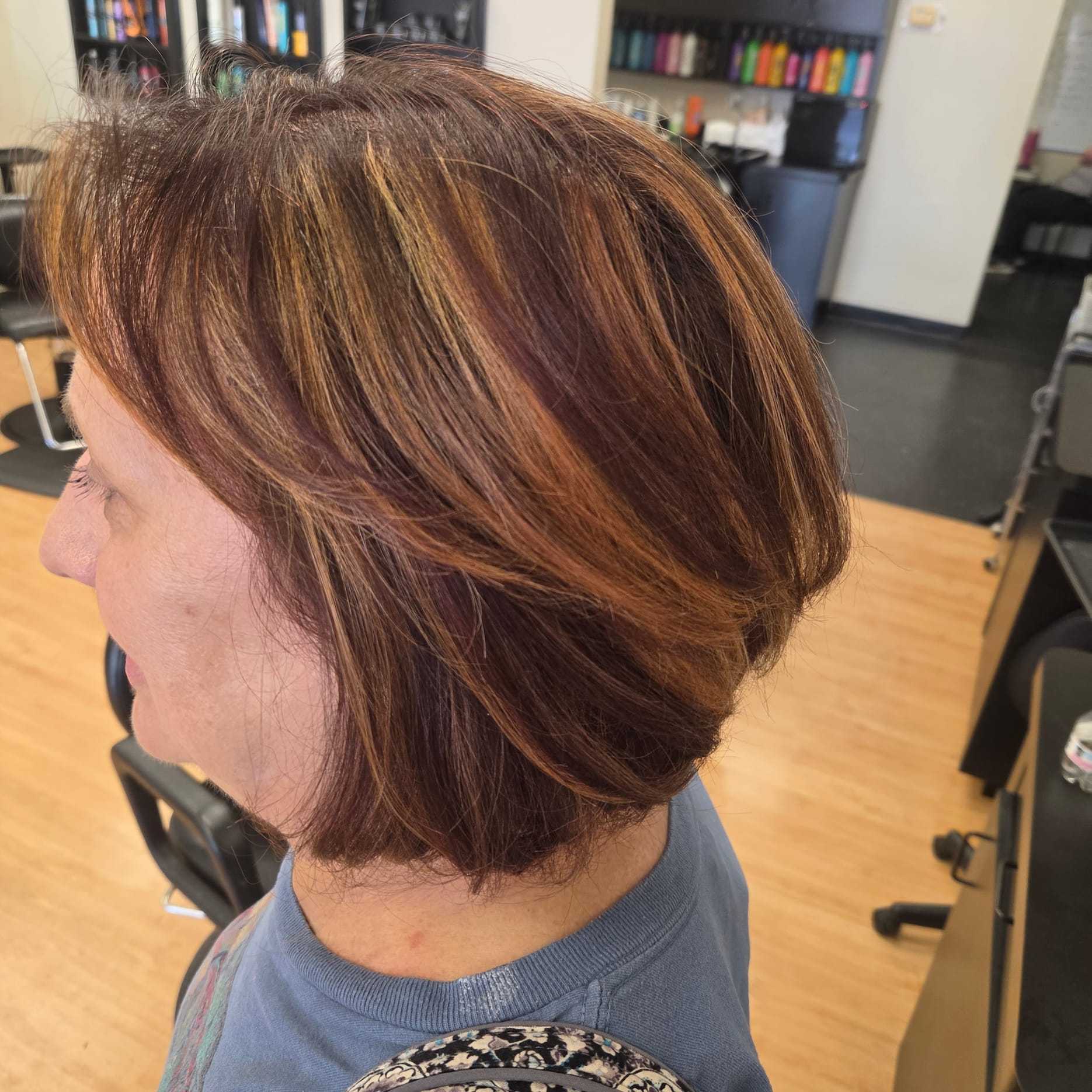 Short-haired woman with highlights in a salon.
