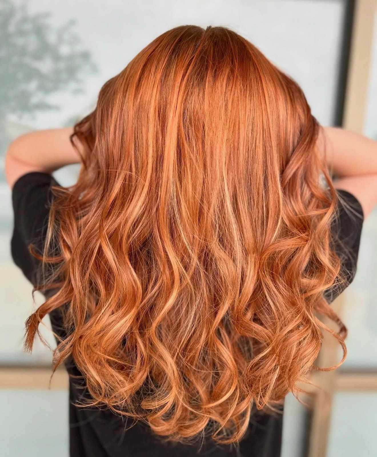 Curly, long, copper-colored hair cascading down a person's back.