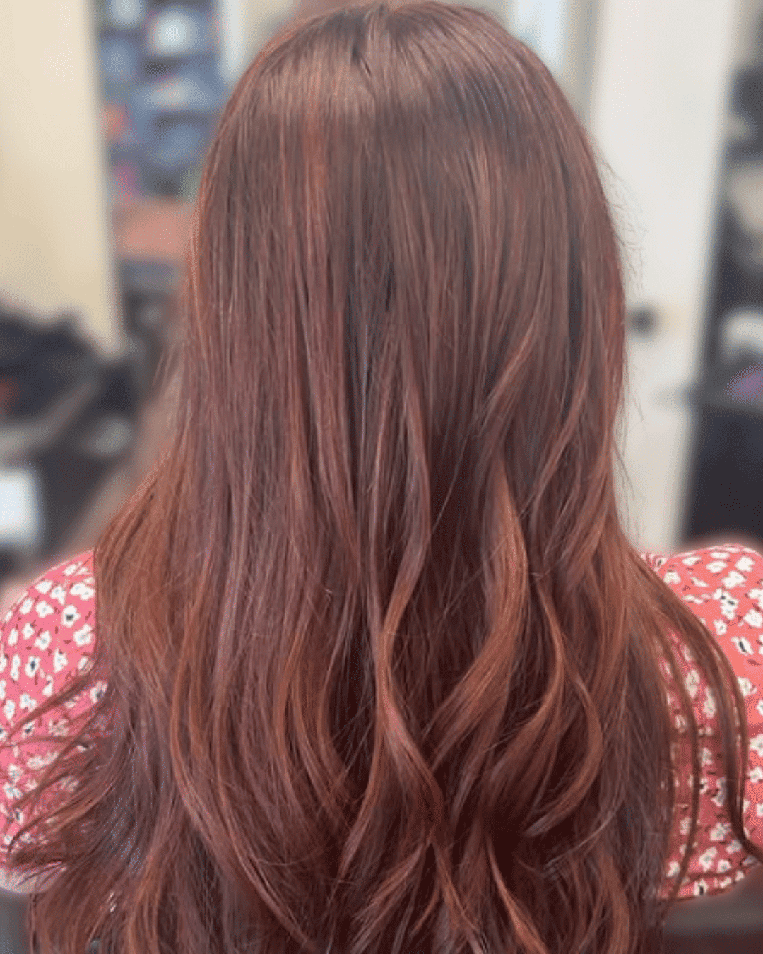 Woman with long, wavy brown hair at a salon.