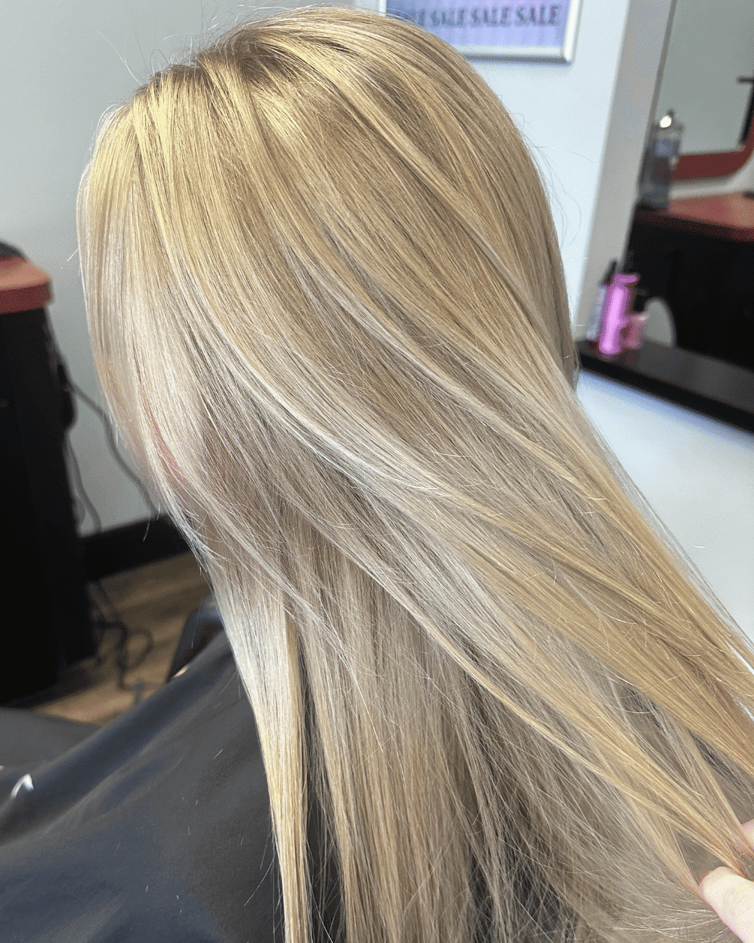 Blond hair styled with smooth, shiny finish in a salon setting.