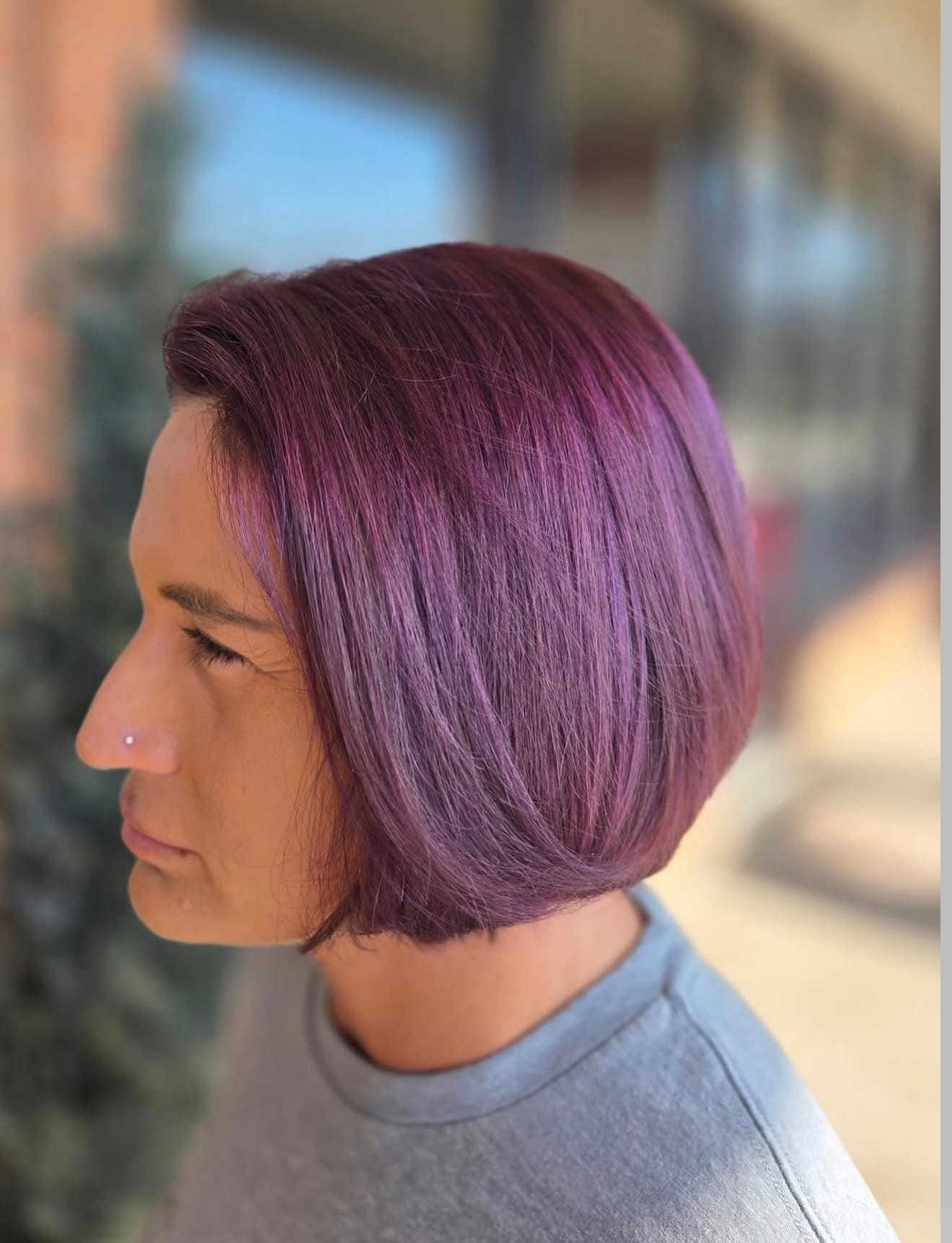 Short purple bob hairstyle on a person wearing a gray top.