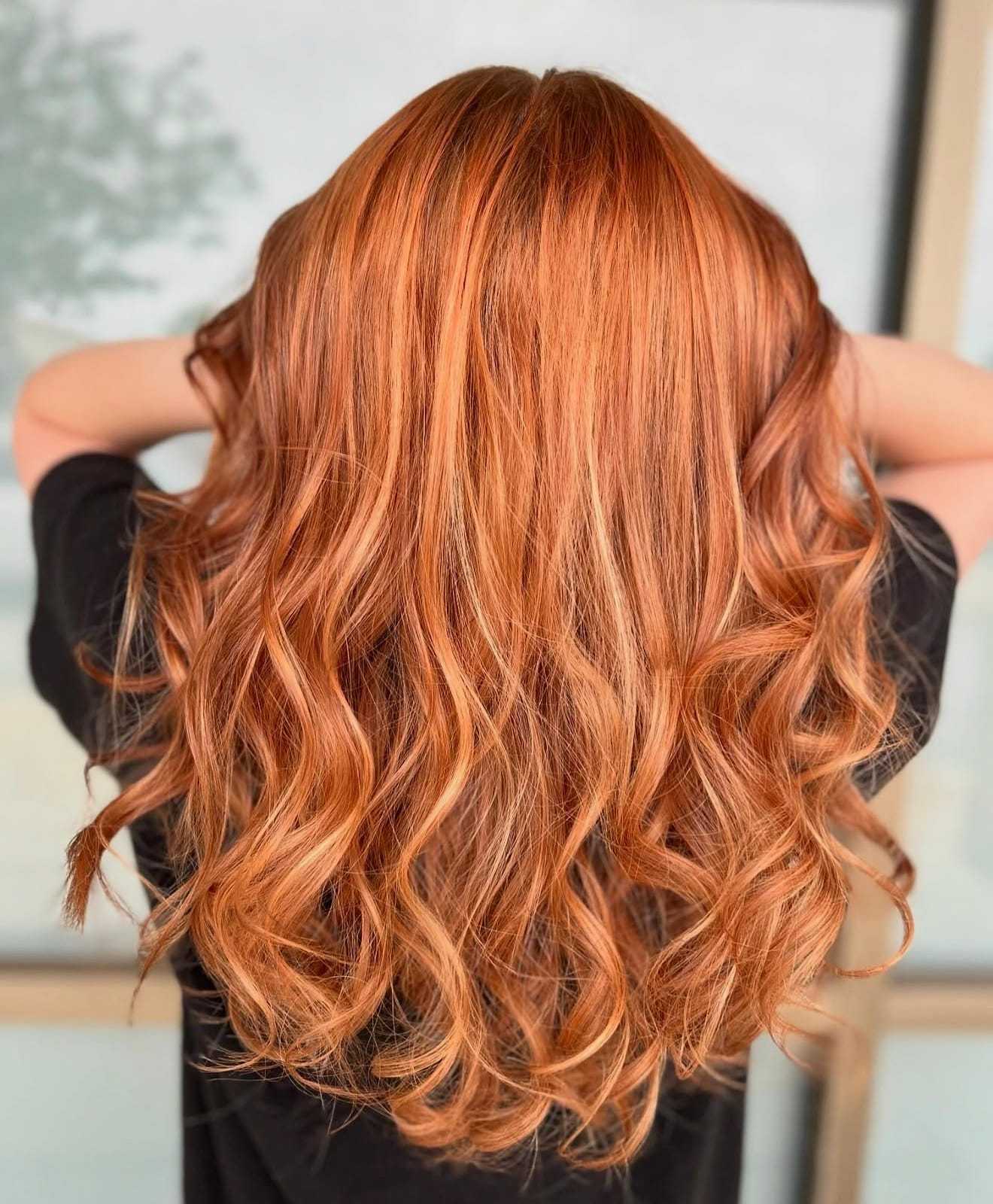 Curly, long, copper-colored hair cascading down a person's back.