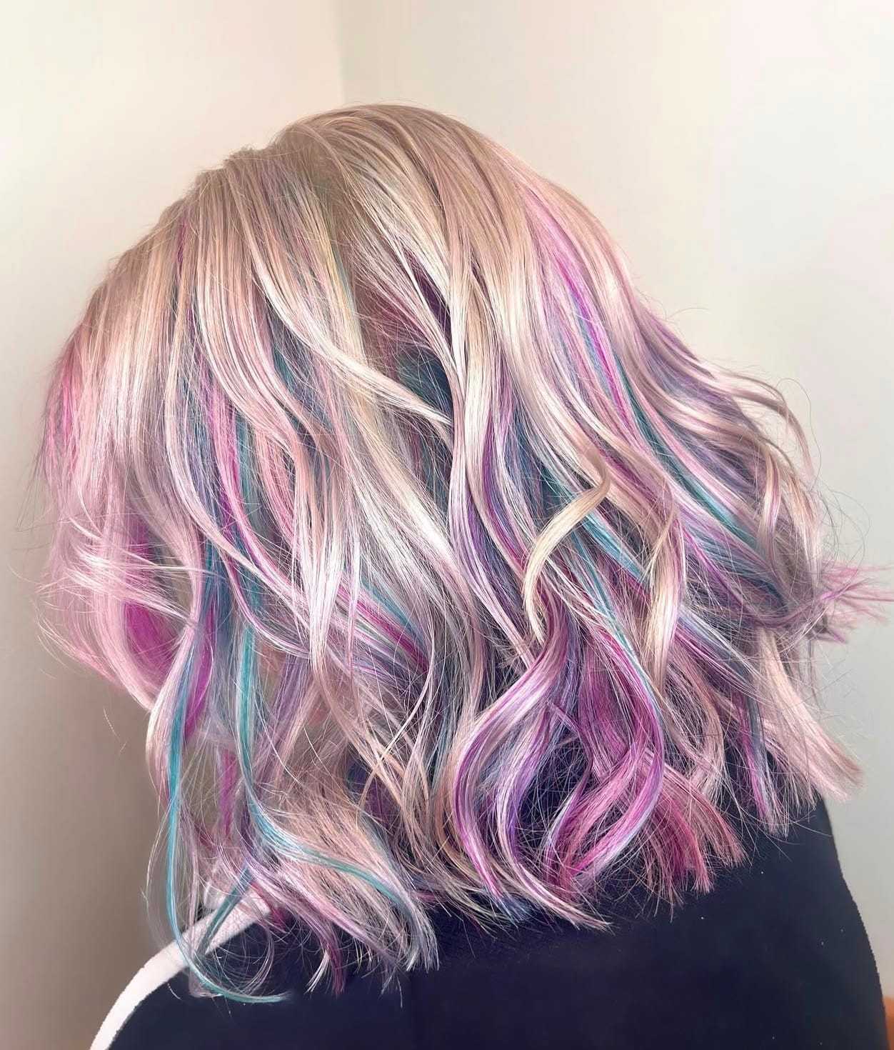 Pastel rainbow-colored wavy hair, showcasing shades of pink, blue, and purple in soft curls.