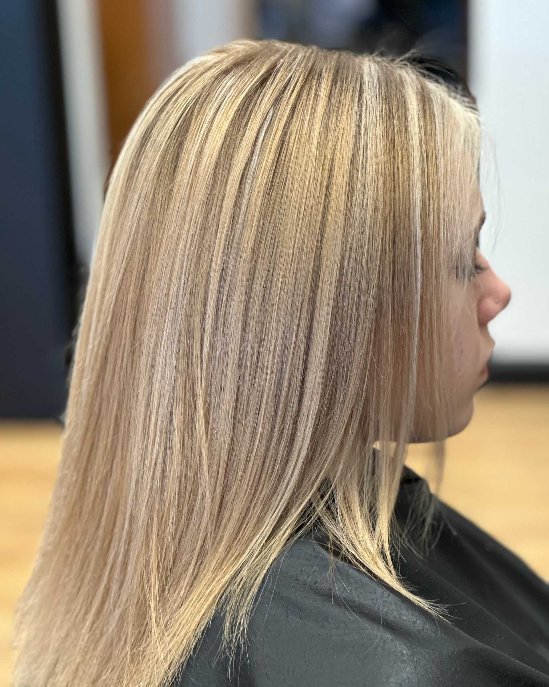 A woman with straight, light blonde hair at a salon.