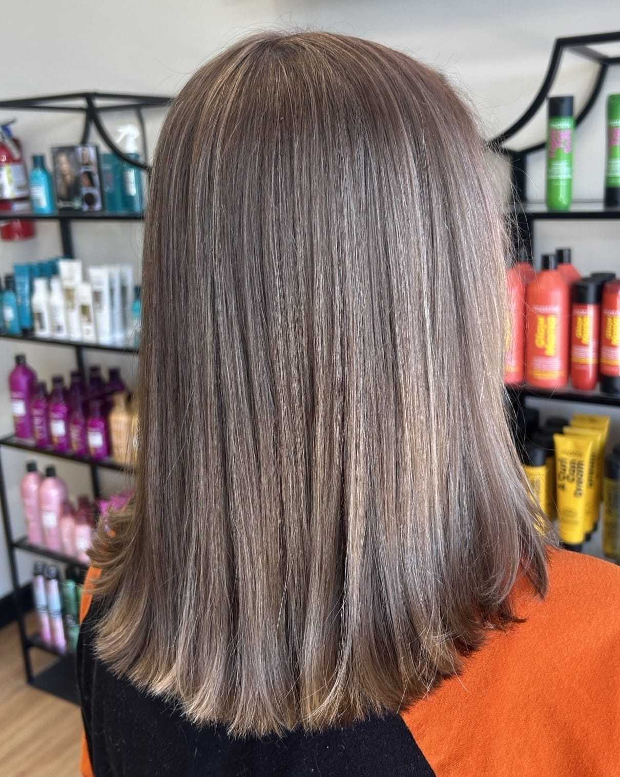 Medium-length hair with smooth, subtle highlights in a salon setting.