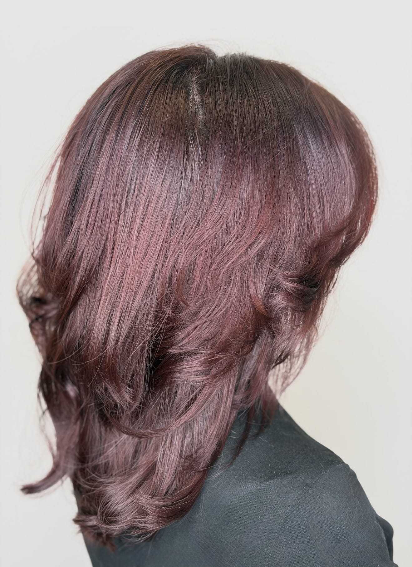 Brunette hair with subtle waves and vibrant highlights, back view.