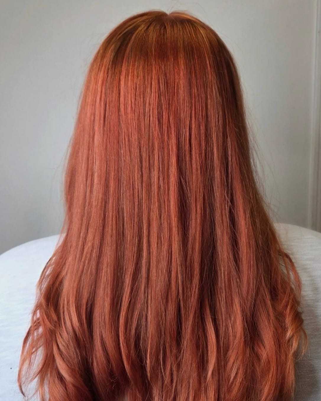 Red-hued straight hair cascading down the back against a light background.