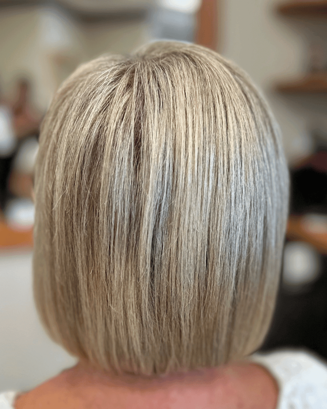 Short blonde bob hairstyle from the back in a salon setting.