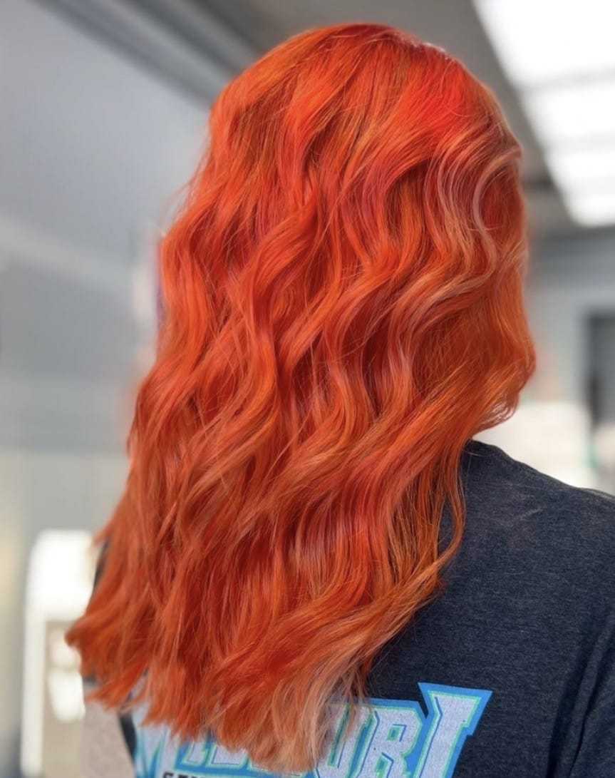 Wavy bright red hair from the back, showing a vibrant and textured hairstyle.