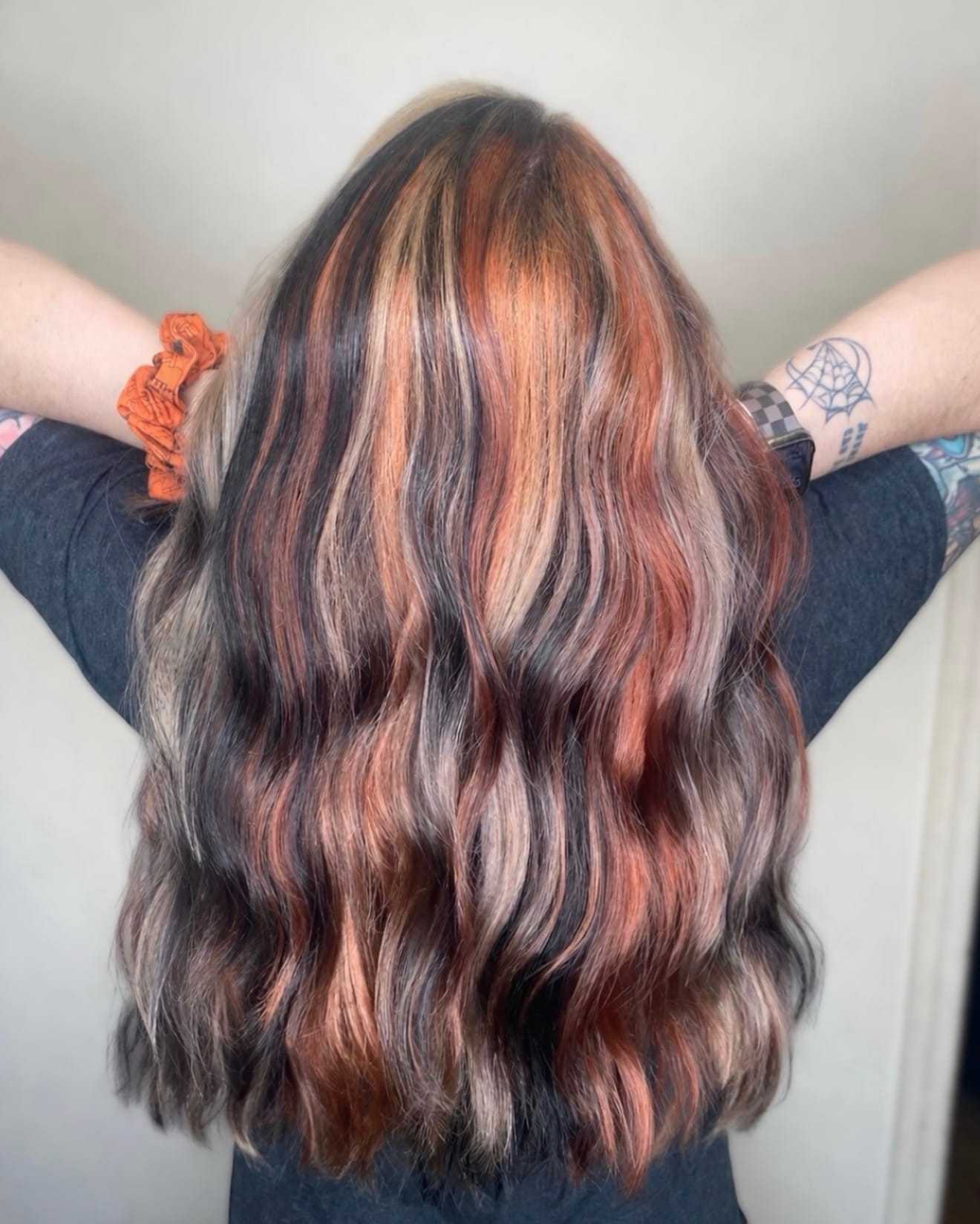Wavy hair with vibrant red, orange, and brown highlights, viewed from the back.